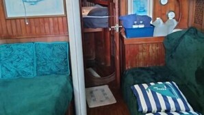 A compact cabin with two beds, a small kitchenette, and a window. - sailboat on the bay ,close to South Beach and Winwood. (Miami)