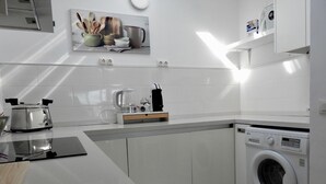 Eine moderne Küche mit integriertem Waschmaschine, einer Kaffeemaschine und einem Toaster.