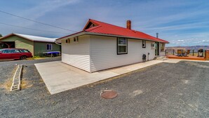 A single-story house with a red roof, a front porch, and a visible garage.