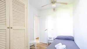 Een slaapkamer met een bed, een bureau en een stoel.
