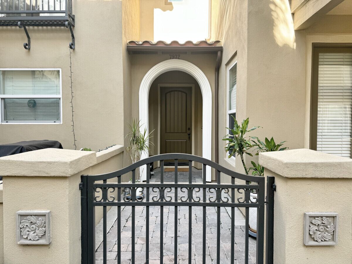 A gated entrance with a decorative archway and a number plaque.