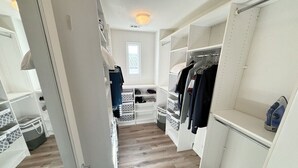 A walk-in closet with open shelves, hanging space, and a shoe rack. - Coastal Condo - Gated, Pool, Spa, Walk To The Beach (Huntington Beach)