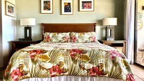 Een hotelkamer met een bed, twee nachtkastjes en drie ingelijste foto’s aan de muur.