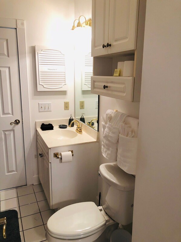 Une petite salle de bain comprenant des toilettes, un lavabo et un miroir.