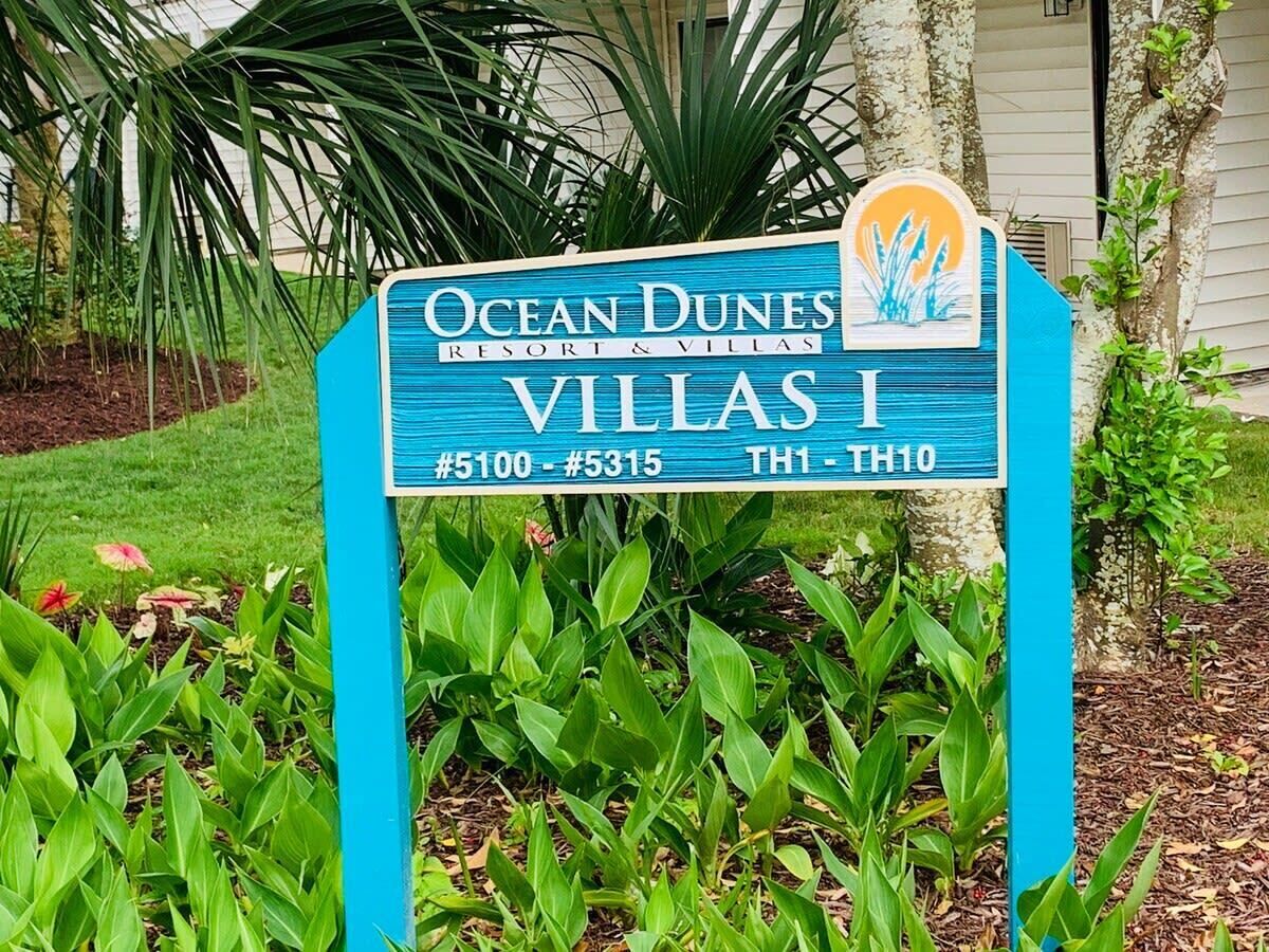 A sign for Ocean Dunes Resort & Villas, indicating Villas 1, 5100-5315, and rooms TH1-TH10.