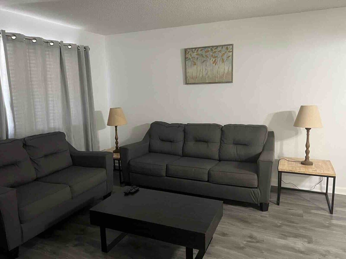 A living room with two sofas, a coffee table, and two lamps.