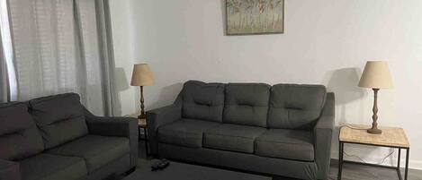 A living room with two sofas, a coffee table, and two lamps.