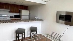 A modern kitchen with wooden cabinets, a stainless steel refrigerator, and a tiled backsplash. - LR1 Bay Tree 1 bedroom condo with pool (Little River)