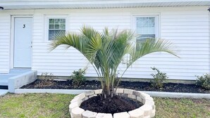 A house with a number '3' on the door, a palm tree in a raised bed, and a small garden area. - AW3 Stay close to the beach (Myrtle Beach)