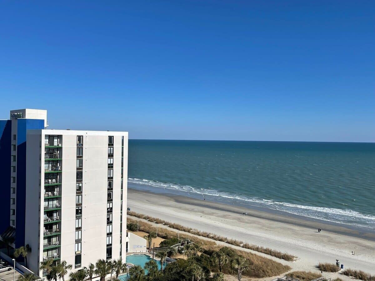 Ein Strandhotel mit Pool, Meerblick und Sandstrand.