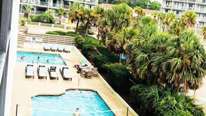 A swimming pool with lounge chairs and palm trees. - BLUE WATER RESORT#12, Ocean view beautiful condo (Myrtle Beach)