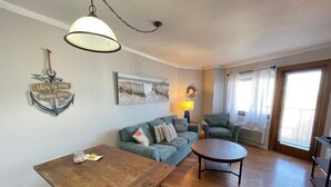 A living room with a wooden table, a sofa, a round coffee table, and a lamp. - BLUE WATER RESORT#12, Ocean view beautiful condo (Myrtle Beach)