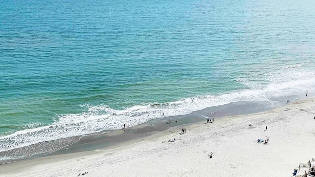 A beach with people walking and relaxing. - BLUE WATER RESORT#12, Ocean view beautiful condo (Myrtle Beach)