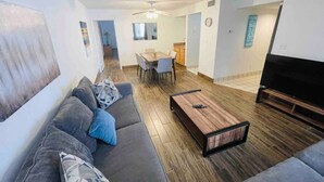 A modern living room with a grey sofa, a wooden coffee table, and a flat-screen TV. - Ocean Dunes Villas #17, short walk to the beach (Myrtle Beach)