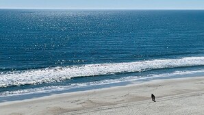 A beach with a person walking along the shore. - OD tower II #14, ocean view Fantastic condo + pool (Myrtle Beach)