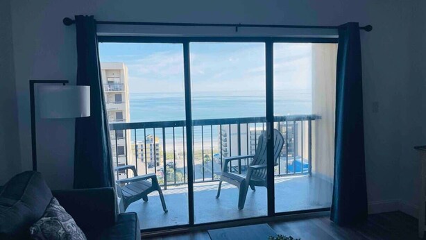 A balcony with a view of the sea, a chair, and a table. - OD tower II #14, ocean view Fantastic condo + pool (Myrtle Beach)
