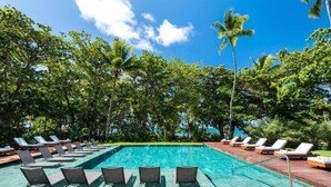 A pool area with lounge chairs and palm trees. - Casa 3A Tivoli Ecoresidences - Queen Room 2

 (Açu da Torre)
