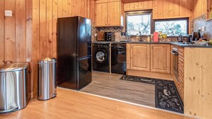 A compact kitchen with wooden cabinets, a stainless steel refrigerator, a dishwasher, and a sink. - 2 bedroom accommodation in Kilmorack, near Beauly (Kilmorack, near Beauly)