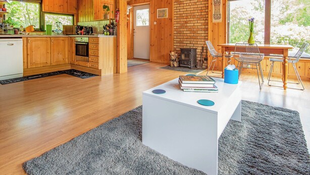 A spacious kitchen with wooden cabinets and a brick wall, a dining area with a table and chairs, and a cozy fireplace. - 2 bedroom accommodation in Kilmorack, near Beauly (Kilmorack, near Beauly)