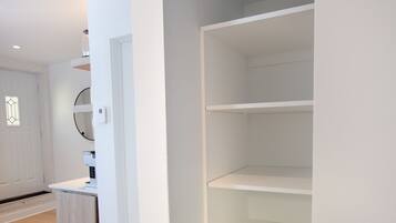 A modern interior with a white wall, a wooden floor, and a white door.