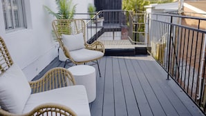 A wooden deck with wicker furniture and a small round table. - Unique Stays - 4119 St-Denis (Montreal)