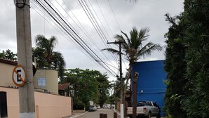 Une rue pavée, avec un panneau indiquant l’interdiction de se garer, des poteaux électriques et un bâtiment bleu en arrière-plan.