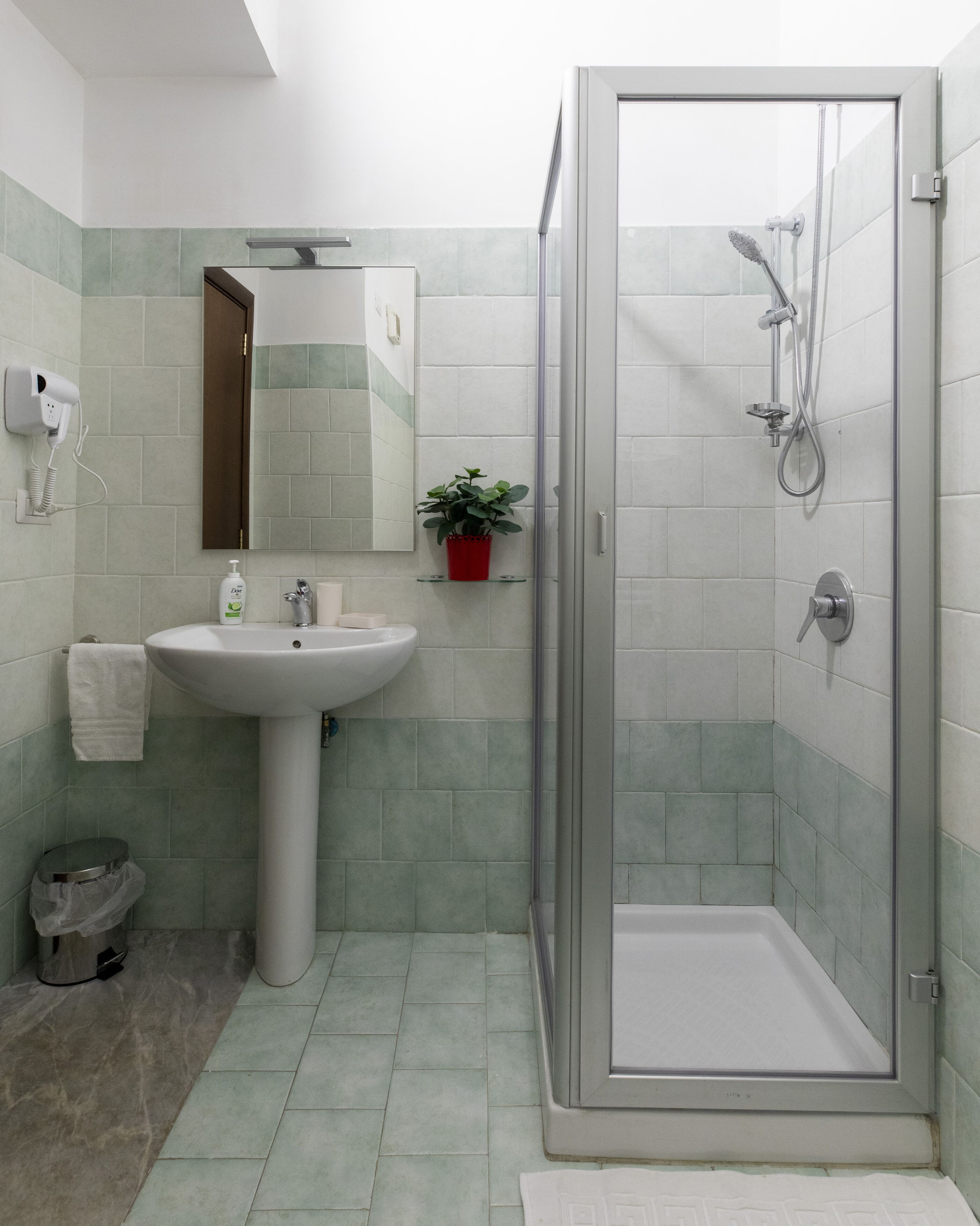 A bathroom with a shower, sink, and toilet.