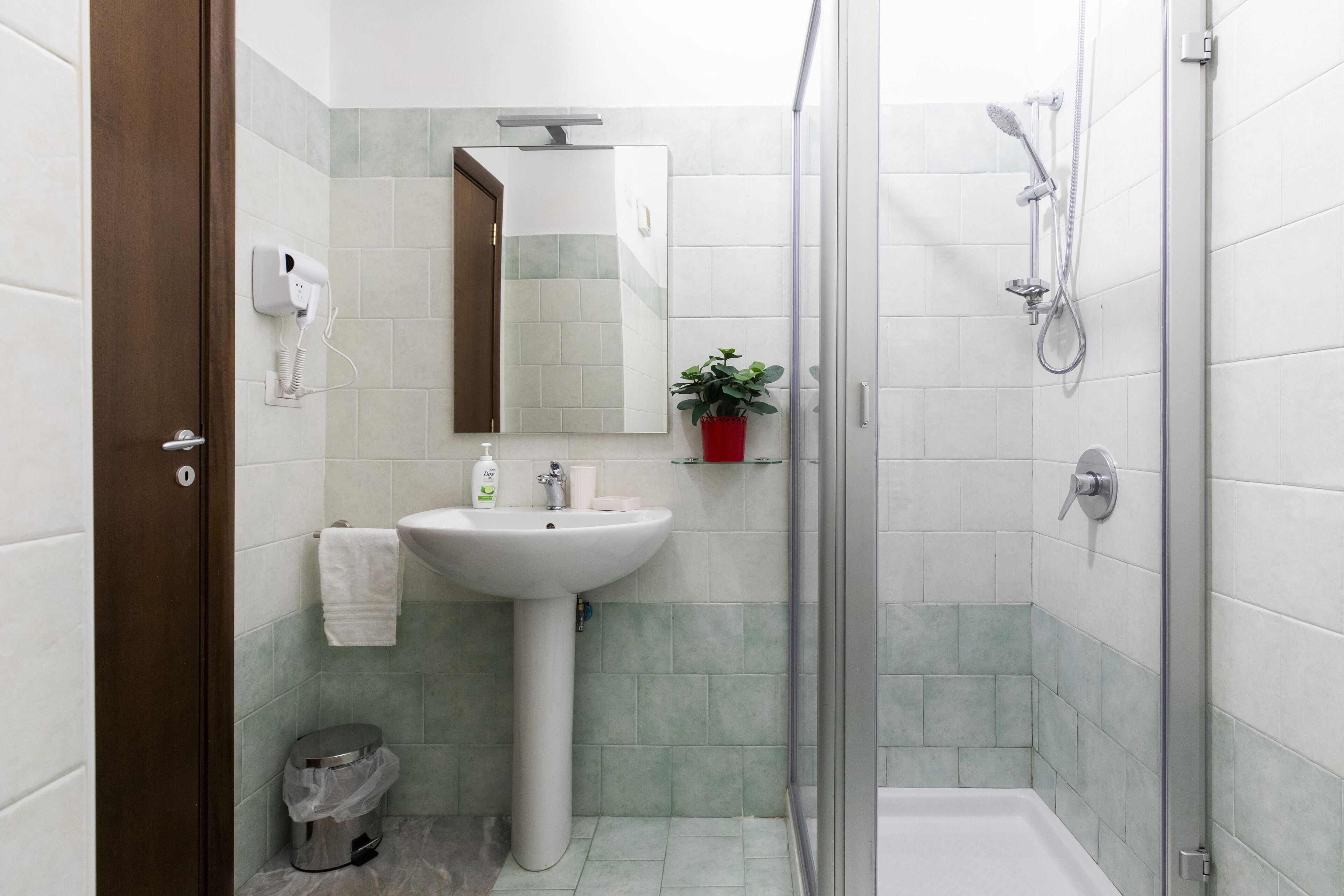 Un baño con lavamanos, espejo y ducha.