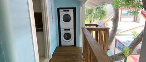 A wooden deck leading to a laundry room with a washing machine and dryer.