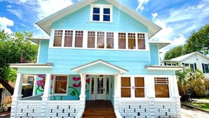 A two-story house with a front porch, a staircase leading to the entrance, and a small garden area. - (1) 320 Unit #1 · Downtown St. Pete/Historic Old NE #1 (St. Petersburg)