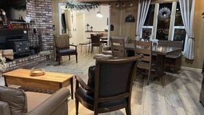 A cozy living room with a fireplace, wooden furniture, and a dining area with a chandelier. - Cozy retreat near Dodge Ridge Ski Resort, and Pinecrest Lake with fast Wi-Fi  (Cold Springs)