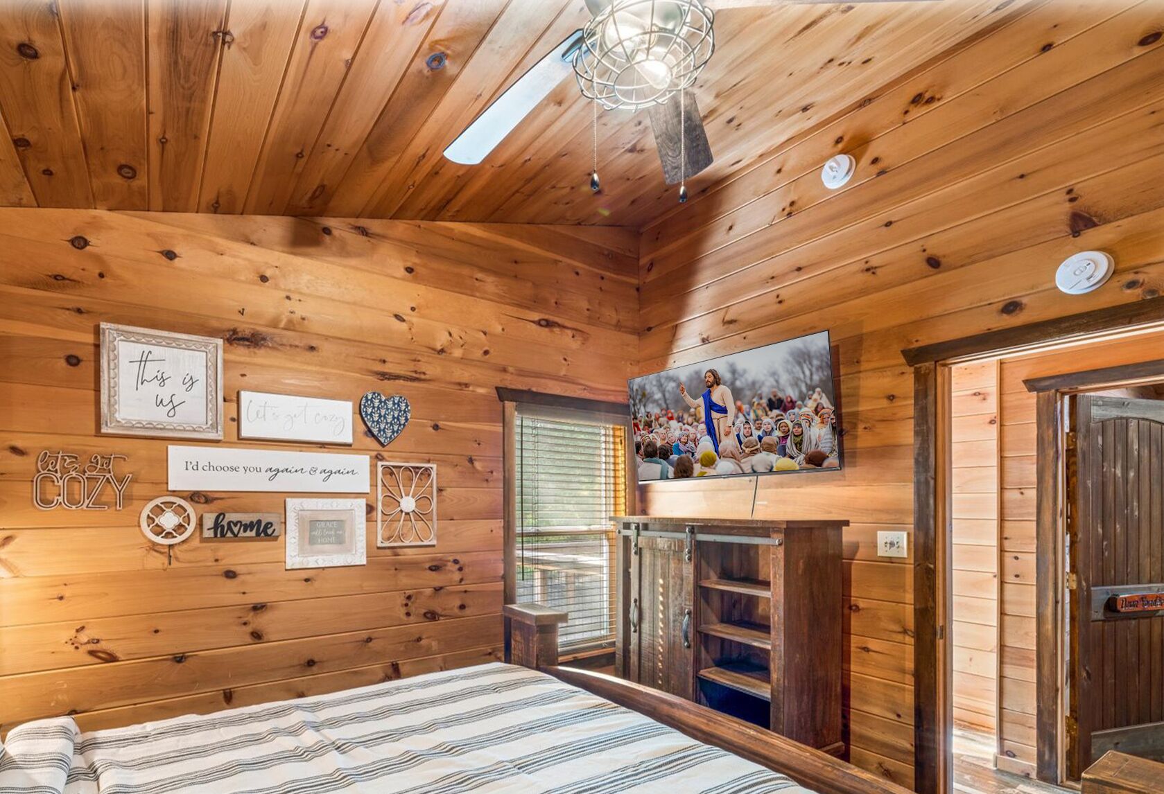 Una habitación acogedora de madera con una cama, un televisor y varias decoraciones en la pared.