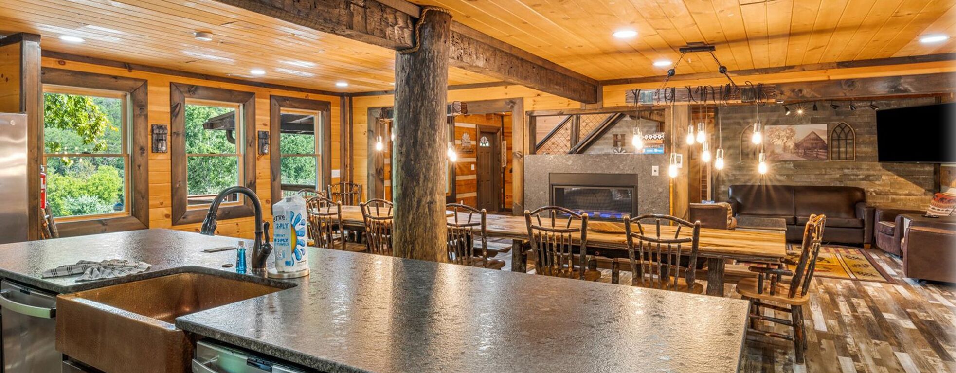 A rustic cabin interior with a kitchen, dining area, and living space.