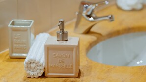 A bathroom sink with a bottle of Savon de Marseille soap and a bar of soap. - Simply bright quad room (BERGAMO)
