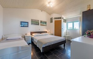 Relax in a serene bedroom with a large bed, bedside tables, and a unique ceiling design.