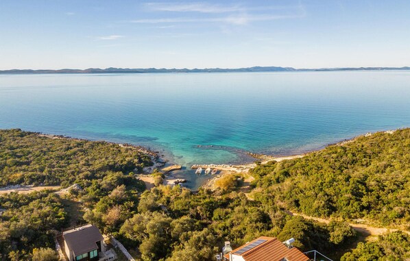 Enjoy a serene coastal retreat with a panoramic sea view, a well-maintained garden, and a dock for water activities.