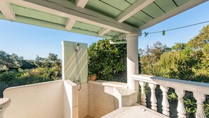 Un espace de douche extérieur abrité, offrant une vue sur la végétation environnante.