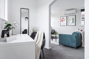 A modern living room with a sofa, a coffee table, and a dining area with chairs.