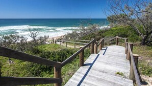 A wooden boardwalk leading to a beach with ocean views. - Beachhaven - walk to beach (Yaroomba)