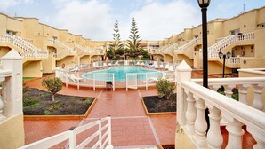 A courtyard with a swimming pool, white railings, and a lamp post. - Holiday Apartment 'Liomor Luxury' with Shared Pool, Wi-Fi and Air Conditioning (Caleta de Fuste)