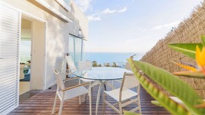 A deck with a glass table and white chairs, overlooking the sea. - Apartment 'Sitges Suites B' with Sea View, Wi-Fi and Air Conditioning (Sitges)