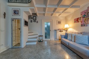 A spacious living area with a staircase, a sofa, and a lamp.