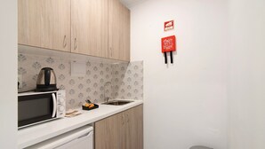 A compact kitchen with a microwave, sink, and cabinets. - Apartment 'Seashel' with Shared Terrace, Wi-Fi and Air Conditioning (Moncarapacho)