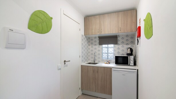 A compact kitchen with a microwave, sink, and a dishwasher.
