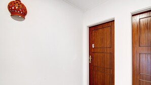 A hallway with a wooden door marked with the number 6, a light fixture, and a wooden floor. - Apartment 'Sunset' with Shared Terrace, Wi-Fi and Air Conditioning (Moncarapacho)