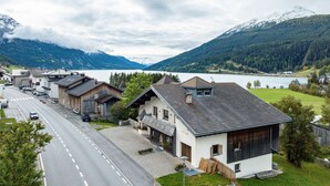 A mountain village with a road, houses, and a lake. - Holiday Apartment 'Appartements Egart 1' with Lake View, Balcony and Wi-Fi (Reschen)