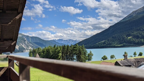 A mountain landscape with a lake, forested hills, and a clear sky. - Holiday Apartment 'Appartements Egart 2' with Lake View, Balcony and Wi-Fi (Reschen)
