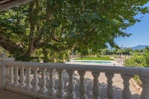 Um jardim com piscina, árvores e céu claro.