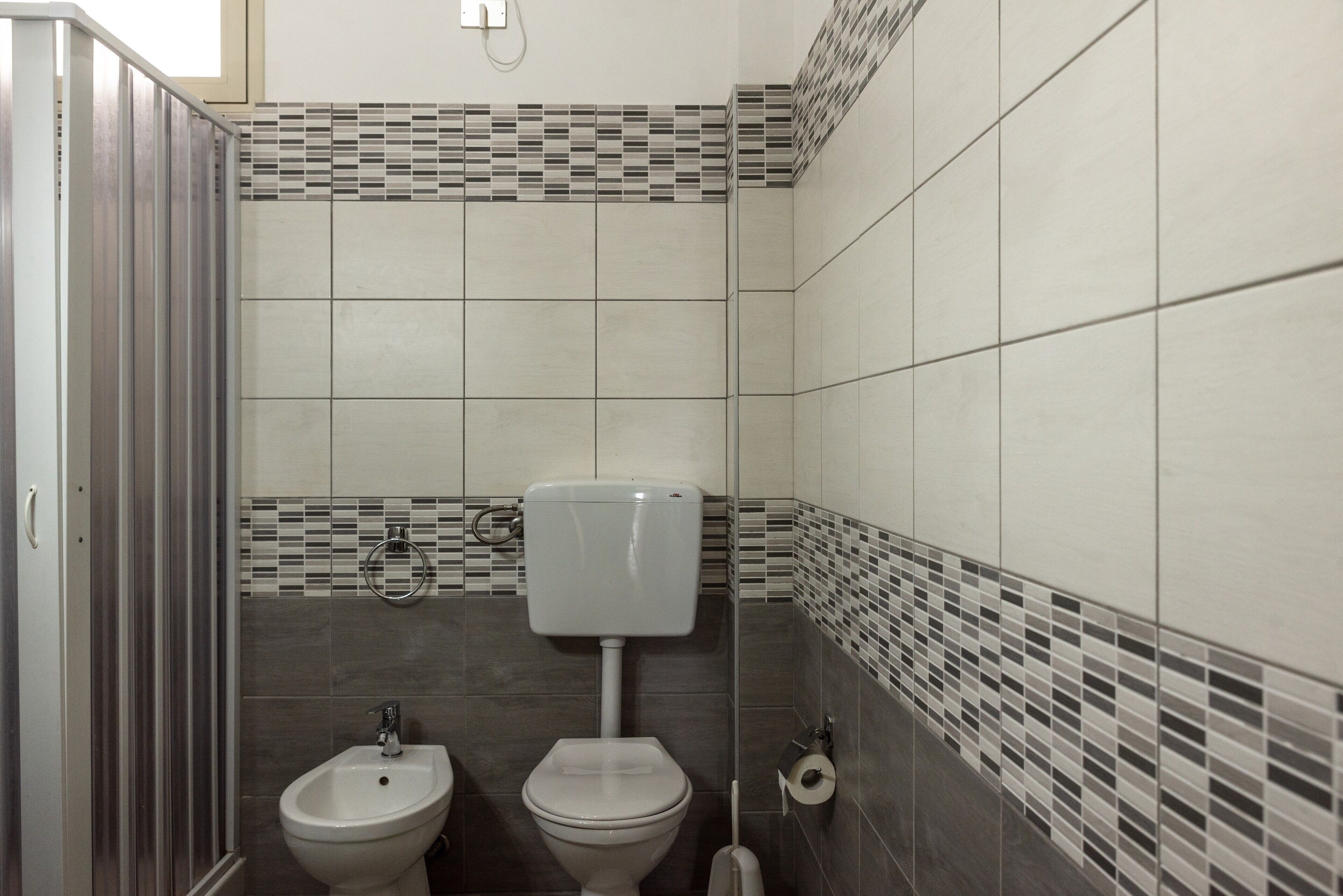 Un baño con inodoro, bidé y zona de ducha.