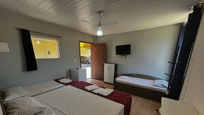 A hotel room with two beds, a desk, a chair, a TV, and a small refrigerator. - Pousada Pé da Serra  (Lindoia)